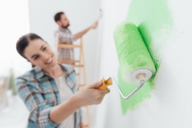 pareja pintando casa