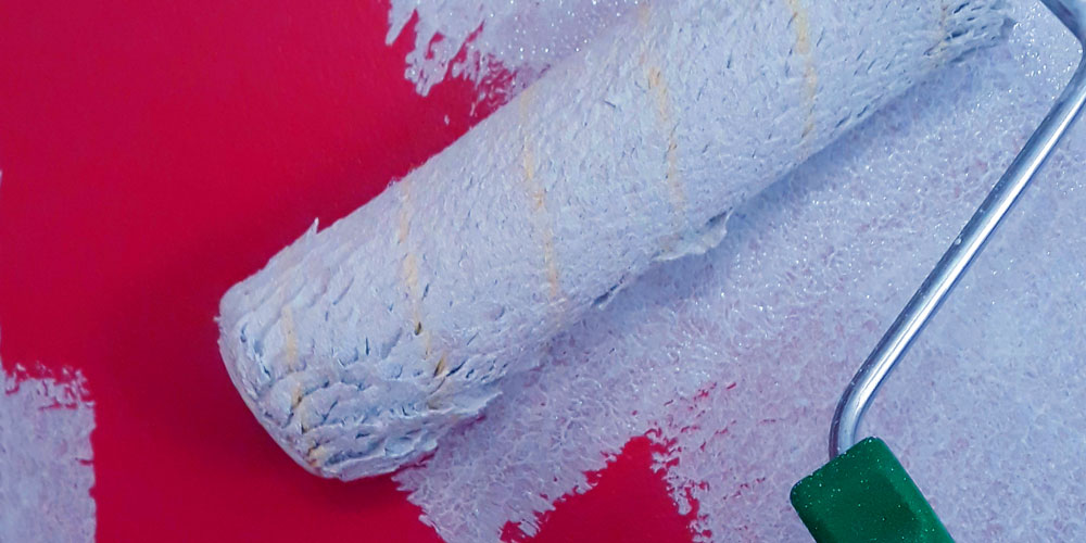 rodillo pintando pared roja
